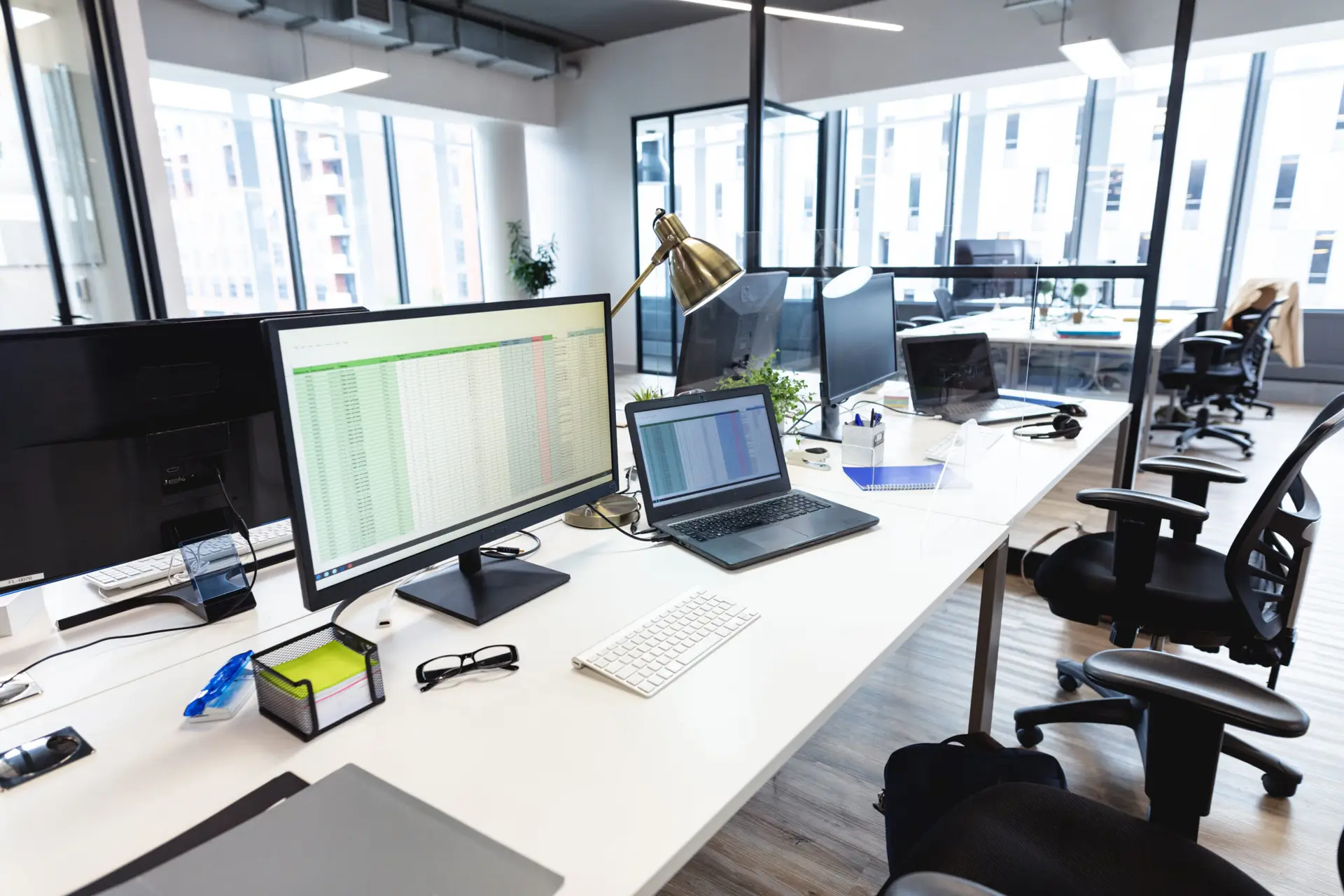Empty modern office with desks, computers and monitors