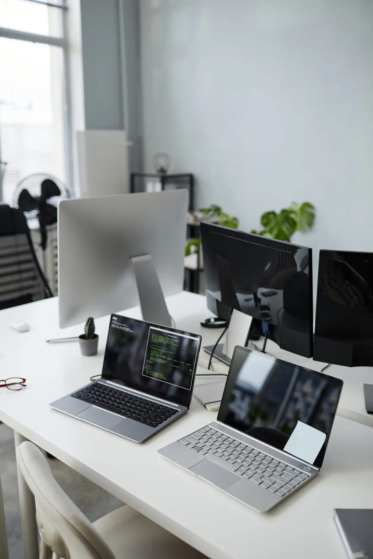 Modern office with laptops and computer monitors on desks